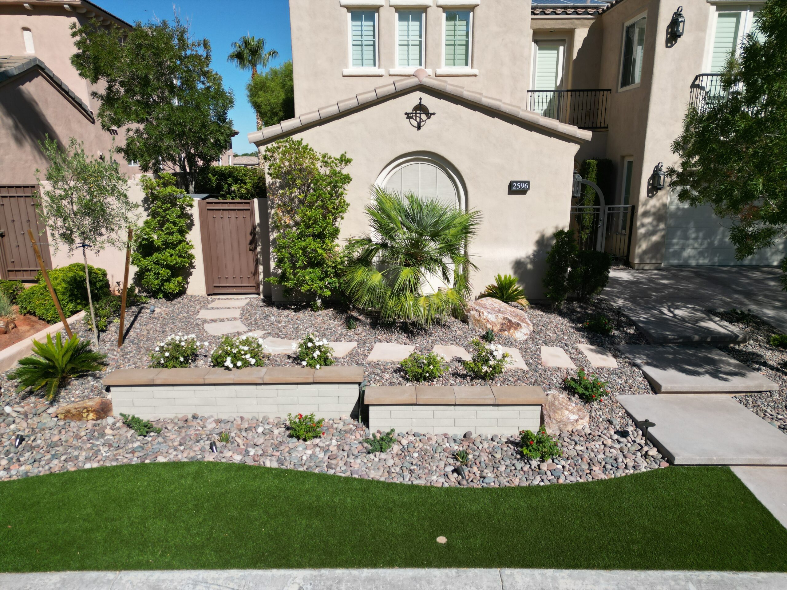 A garden with palm trees and rocks in the yard. A garden with palm trees and rocks in the yard.