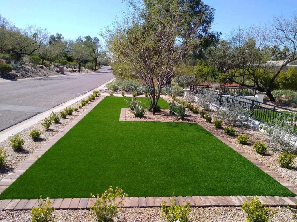 A green lawn with trees and bushes in the background. A green lawn with trees and bushes in the background.
