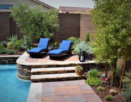 Two lounge chairs are sitting on the side of a pool.